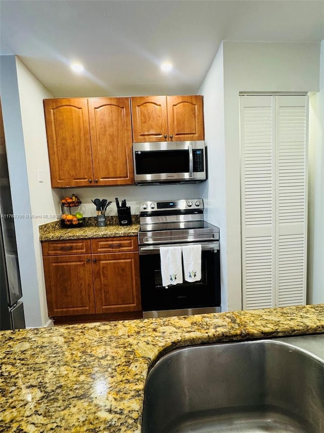 kitchen featuring brown cabinetry, recessed lighting, appliances with stainless steel finishes, and stone countertops