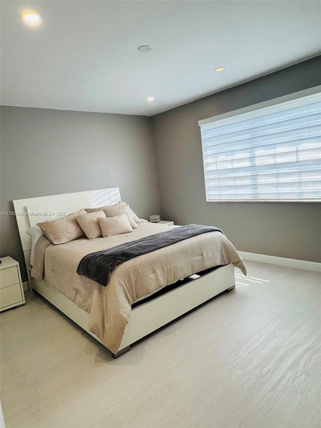 bedroom with baseboards and light wood finished floors