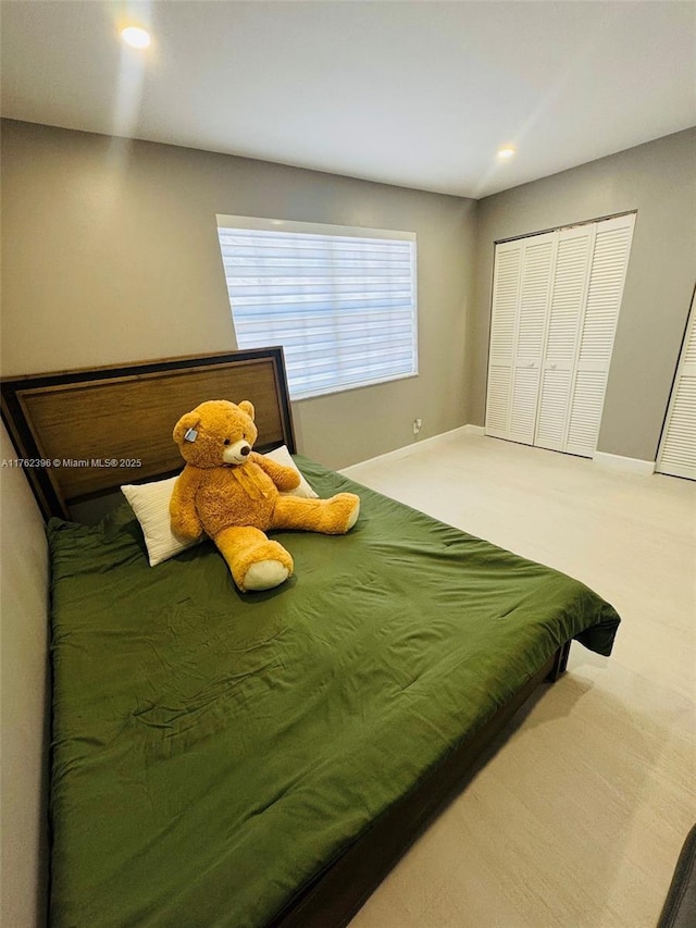 bedroom with a closet, carpet flooring, recessed lighting, and baseboards