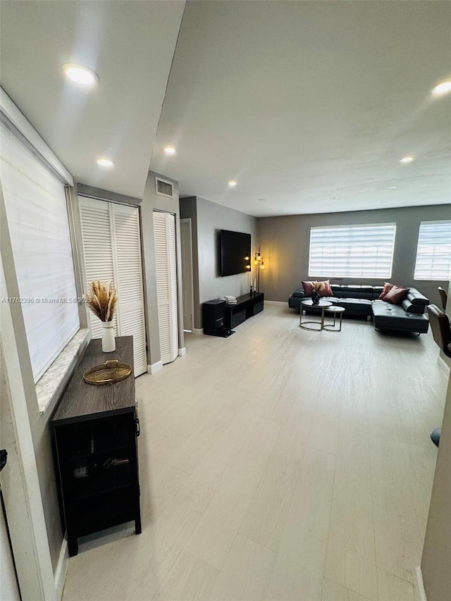 living room with recessed lighting, wood finished floors, visible vents, and baseboards