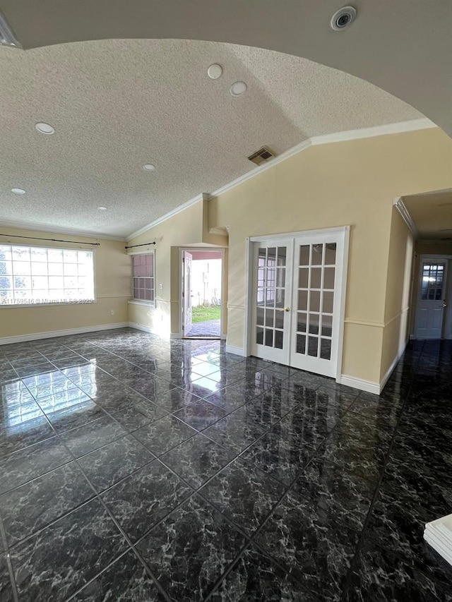 empty room with lofted ceiling, french doors, baseboards, and ornamental molding