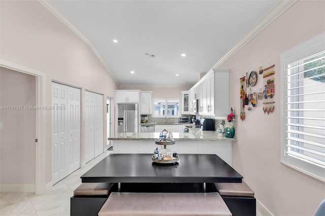 kitchen with visible vents, ornamental molding, decorative backsplash, appliances with stainless steel finishes, and white cabinetry