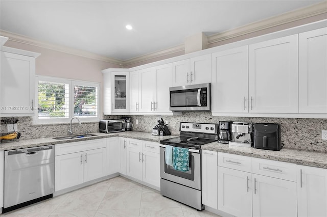 kitchen featuring ornamental molding, a sink, backsplash, white cabinetry, and appliances with stainless steel finishes