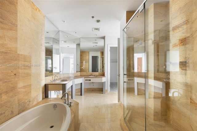 full bathroom featuring vanity, a shower stall, a bath, and visible vents