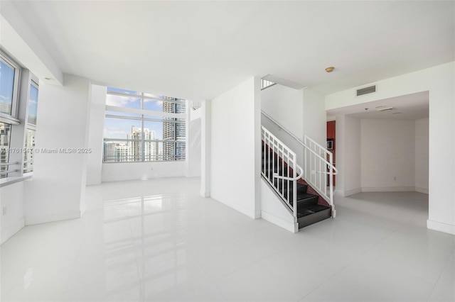 1395 Brickell Ave Unit 3401, Miami, FL 33131 - tiled empty room with stairs, visible vents, baseboards, and a view of city