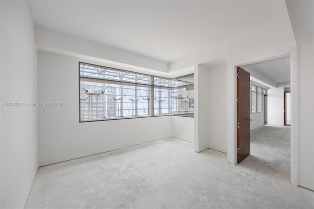 unfurnished room with unfinished concrete floors