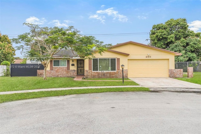 view of front facade with brick siding, fence, concrete driveway, a front yard, and a garage