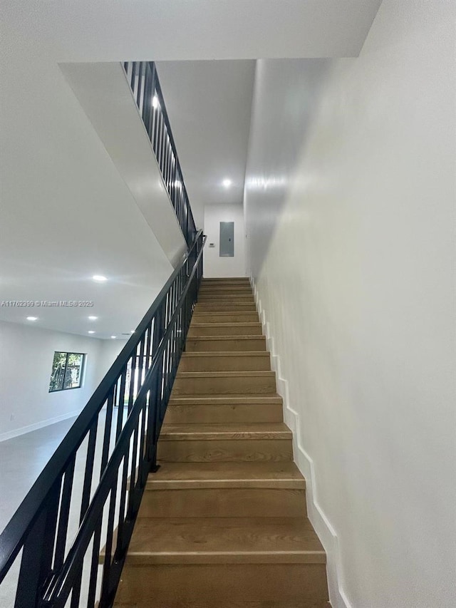 stairway with baseboards and wood finished floors