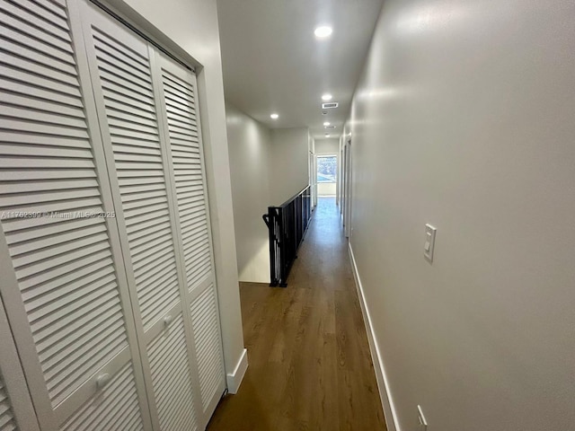 corridor with visible vents, an upstairs landing, wood finished floors, recessed lighting, and baseboards