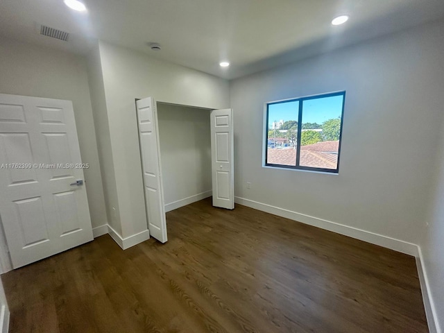 unfurnished bedroom featuring dark wood-style floors, recessed lighting, baseboards, and visible vents