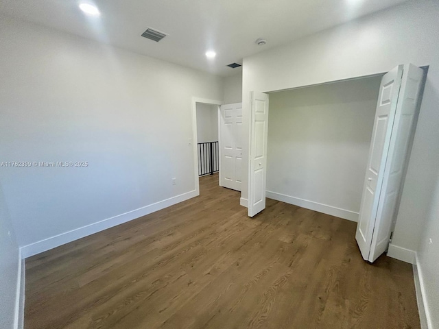 unfurnished bedroom featuring visible vents, baseboards, recessed lighting, wood finished floors, and a closet