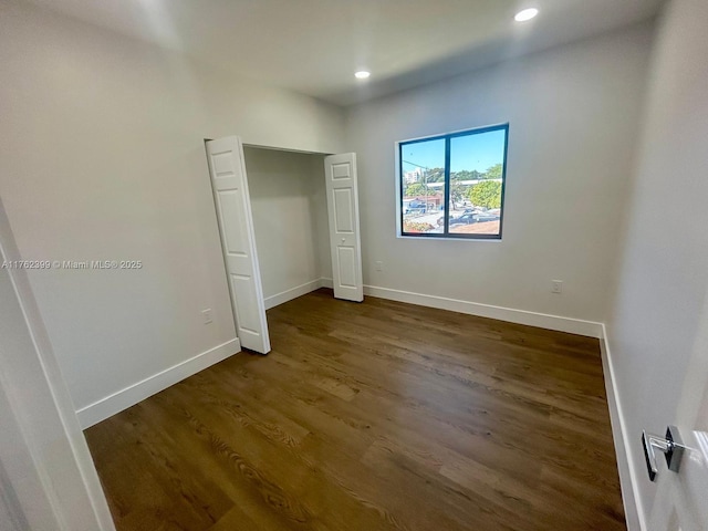 unfurnished bedroom with recessed lighting, baseboards, and dark wood-style flooring