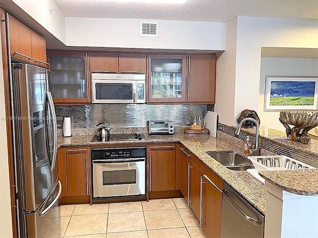 kitchen featuring a peninsula, tasteful backsplash, visible vents, and stainless steel appliances