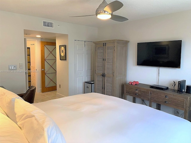 bedroom with light tile patterned floors, a ceiling fan, visible vents, and a closet