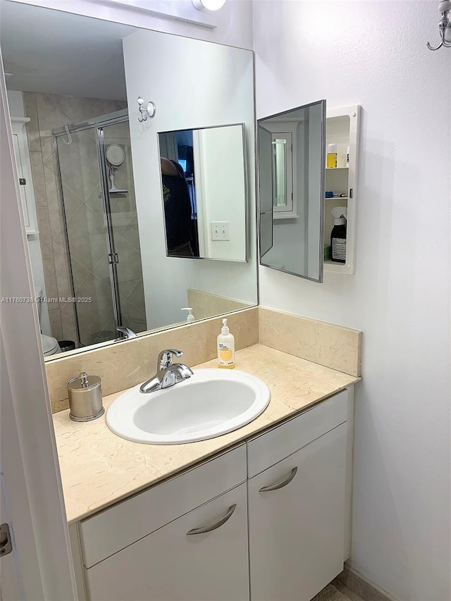 full bathroom featuring a stall shower and vanity