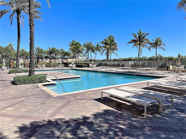 community pool with a patio and fence