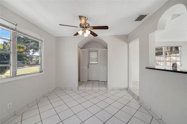 spare room featuring light tile patterned floors, visible vents, and ceiling fan