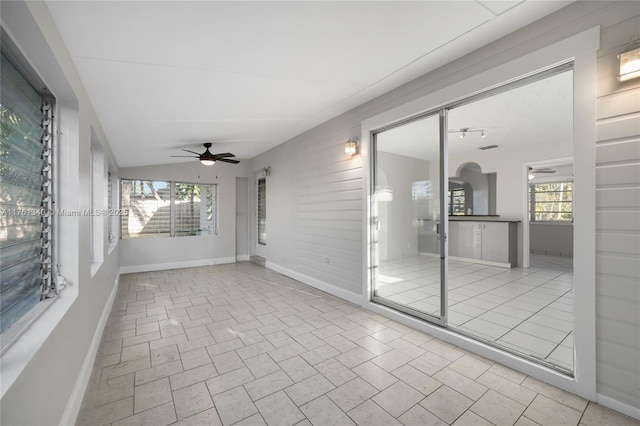 unfurnished sunroom featuring a healthy amount of sunlight and ceiling fan