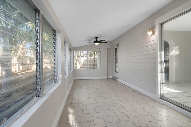 unfurnished sunroom featuring ceiling fan and vaulted ceiling