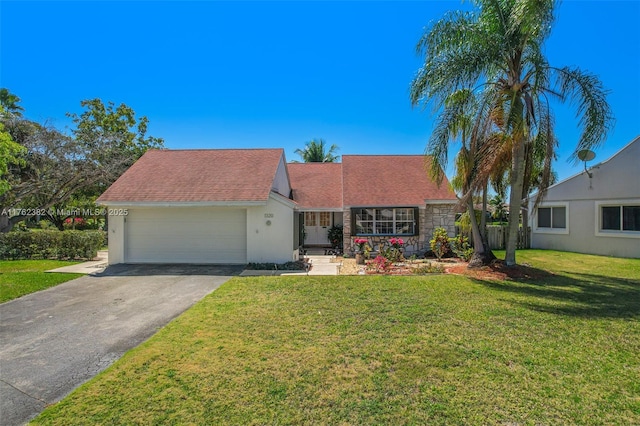 view of front of home featuring a front lawn, roof with shingles, driveway, stone siding, and an attached garage