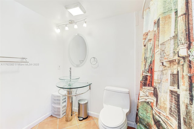 full bath featuring tile patterned floors, baseboards, toilet, and a shower with shower curtain