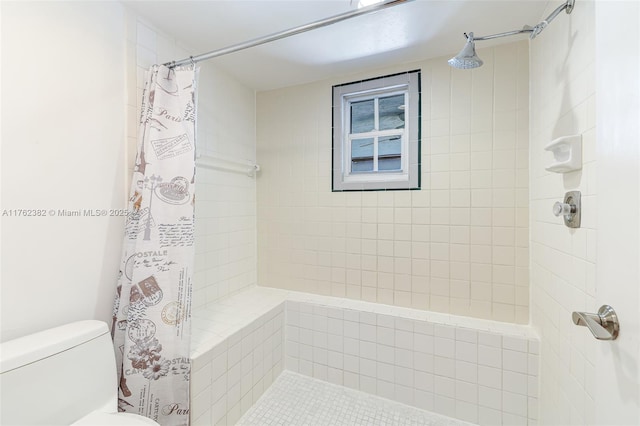 bathroom with toilet and a tile shower