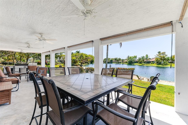 view of patio / terrace with outdoor dining area, a water view, and ceiling fan