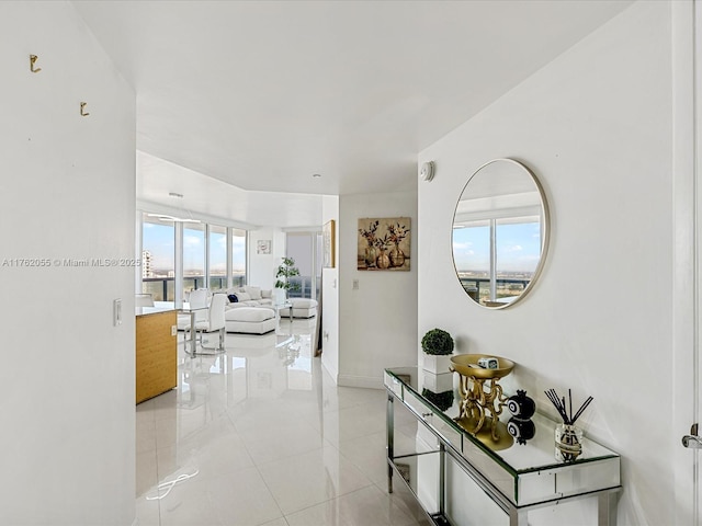 corridor featuring light tile patterned flooring and baseboards