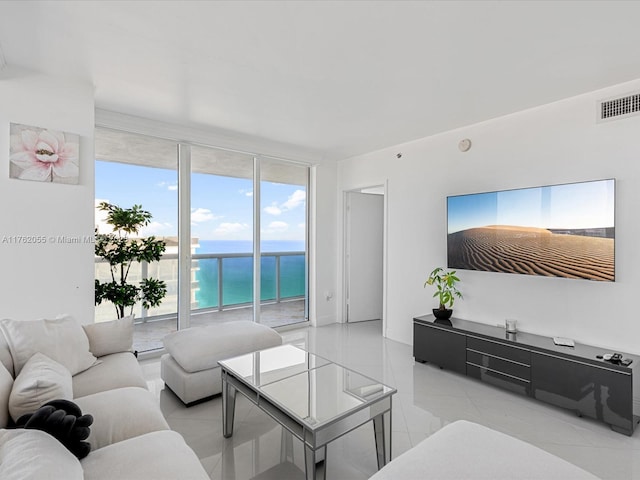 living room featuring baseboards, visible vents, and a wall of windows