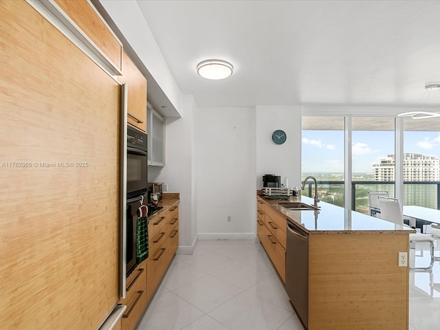 kitchen with light stone countertops, stainless steel dishwasher, a sink, light tile patterned flooring, and a peninsula
