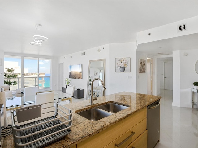 kitchen featuring open floor plan, floor to ceiling windows, a sink, dishwasher, and light stone countertops