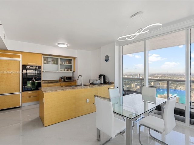 dining room featuring floor to ceiling windows, light tile patterned floors, an inviting chandelier, and a toaster