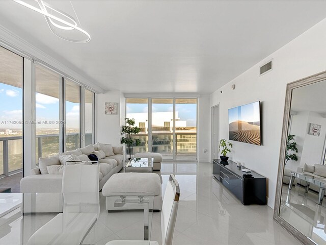 living area featuring baseboards, expansive windows, and visible vents