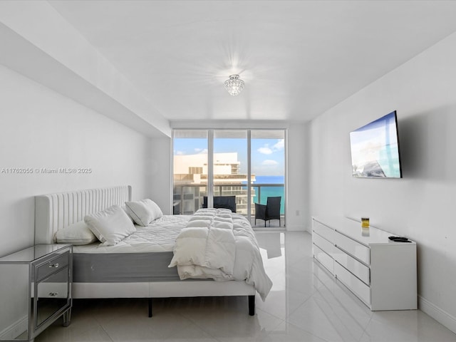 bedroom featuring baseboards, access to exterior, and a wall of windows