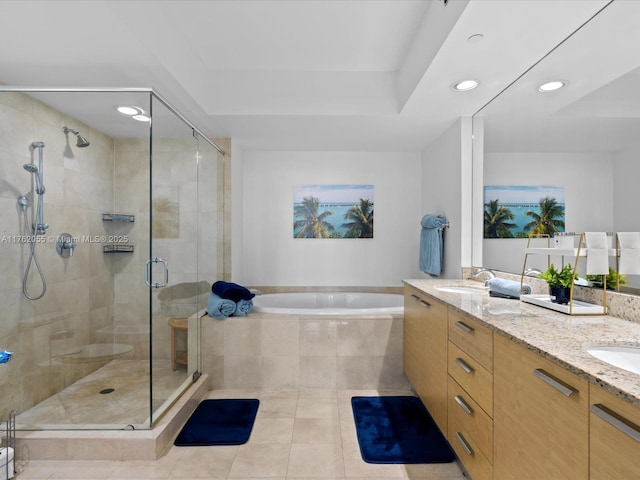 bathroom with a bath, double vanity, a stall shower, and tile patterned floors