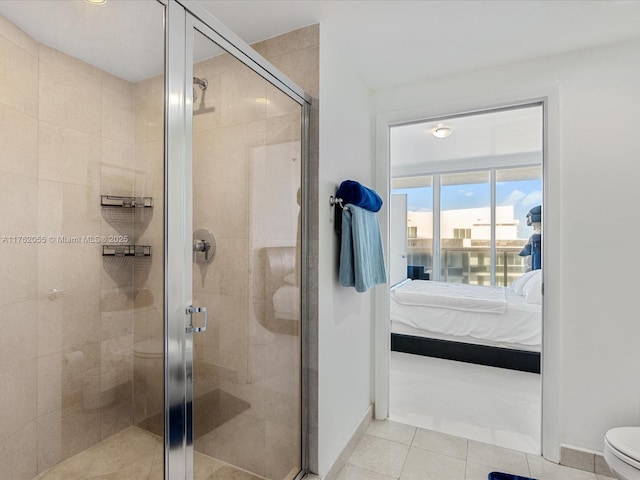 bathroom featuring tile patterned floors, toilet, a shower stall, ensuite bathroom, and baseboards