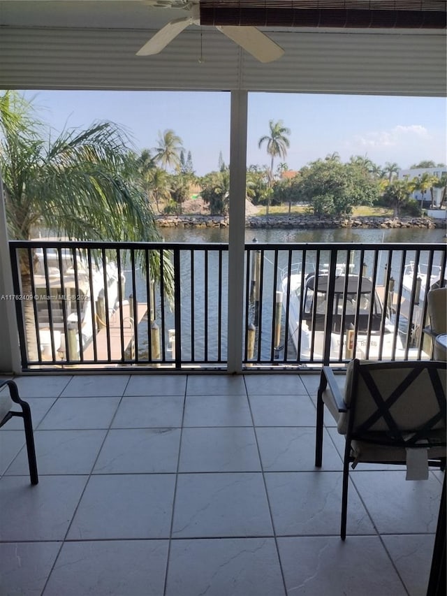 balcony featuring a ceiling fan and a water view