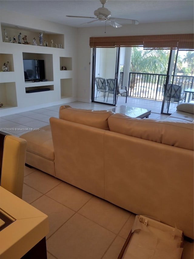 tiled living room with built in features and ceiling fan