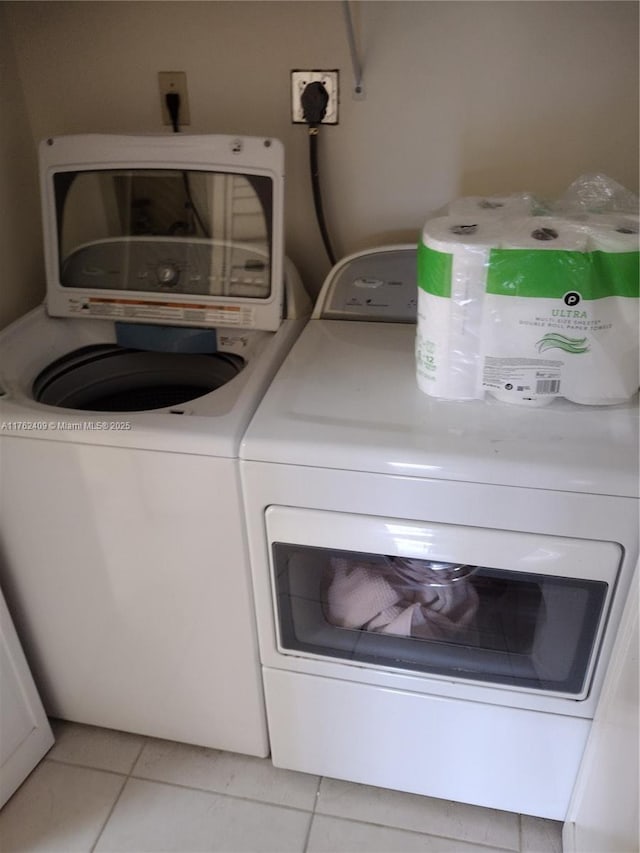 laundry room with light tile patterned floors, independent washer and dryer, and laundry area