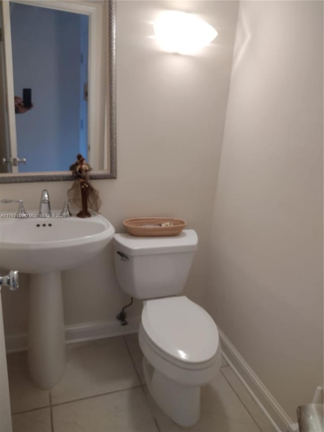 bathroom featuring tile patterned floors, toilet, and baseboards