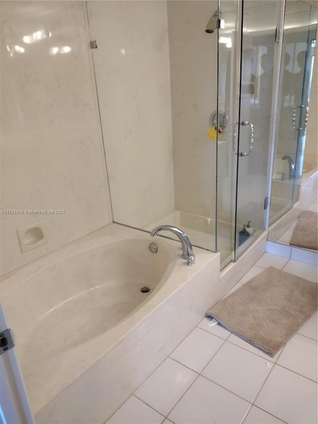 full bathroom with a garden tub, a shower stall, and tile patterned flooring