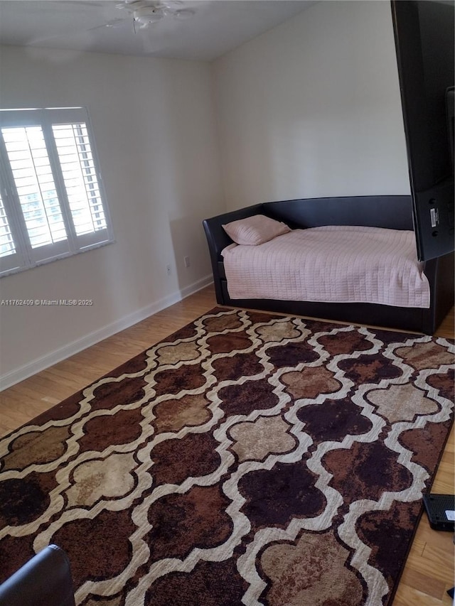 bedroom featuring baseboards and wood finished floors