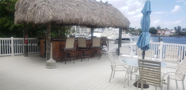 deck featuring outdoor dining space, a gazebo, a water view, and outdoor dry bar