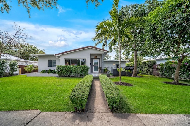 single story home with stucco siding, a front yard, and fence