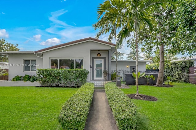 view of front facade with stucco siding and a front yard