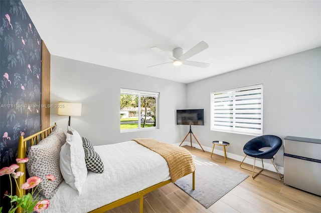 bedroom featuring wood finished floors, baseboards, and ceiling fan