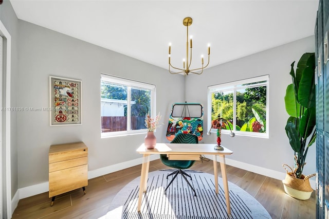 office space featuring a wealth of natural light, an inviting chandelier, and wood finished floors