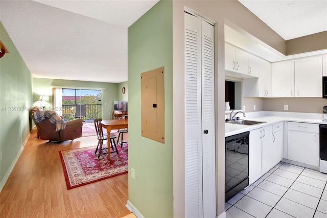 kitchen with open floor plan, dishwasher, light countertops, electric panel, and a sink