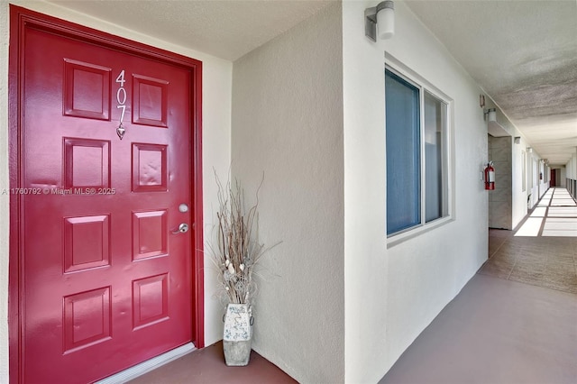 doorway to property featuring stucco siding