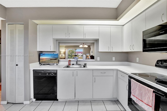 kitchen with a sink, black appliances, white cabinets, and light countertops